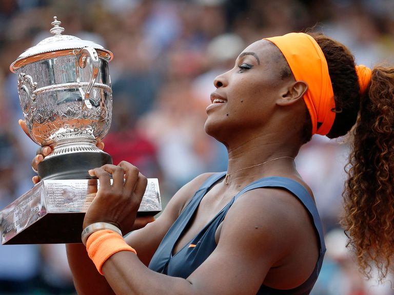 Serena Williams celebrates with the trophy.