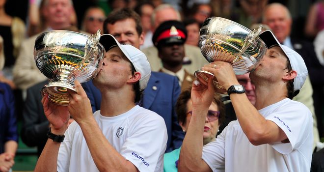 Bob (L) and Mike (R) Bryan kiss their winners' trophies after winning the men's doubles final