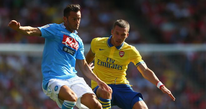 Giandomencio Mesto and Lukas Podolski: Battle for the ball at the Emirates Cup