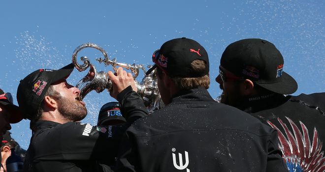 Oracle tactician Sir Ben Ainslie drinks champagne from the America's Cup trophy