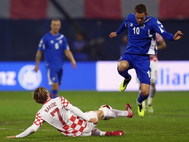 Gylfi Sigurdsson is challenged by Ivan Rakitic.