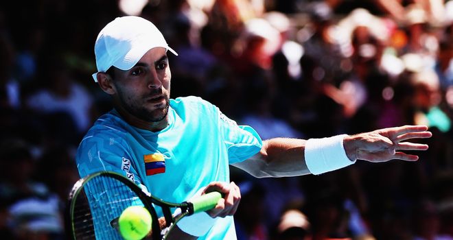 Santiago Giraldo plays a forehand against Albert Montanes
