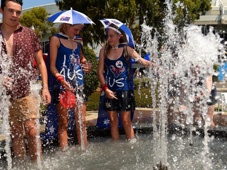 Tennis fans take a dip in a fountain to cool off from the heat on day four of the 2014 Australian Open tennis tournament in Melbourne on January 16, 2014.