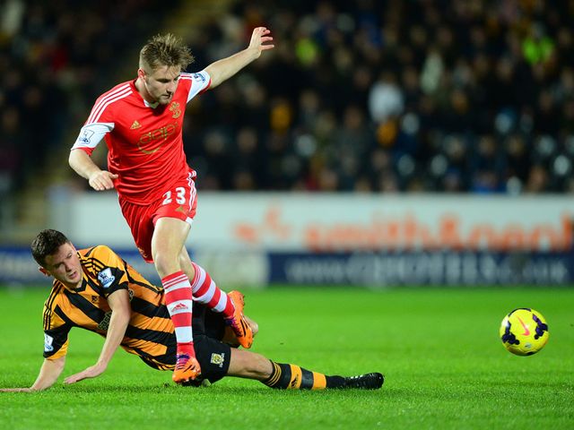 Alex Bruce slides in to tackle Luke Shaw