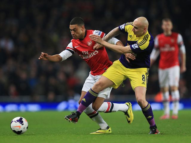 Arsenal's Alex Oxlade-Chamberlain (l) holds off the challenge of Swansea's Jonjo Shelvey