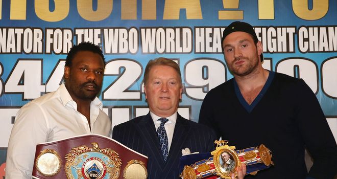 Promoter Frank Warren flanked by Dereck Chisora (L) and Tyson Fury