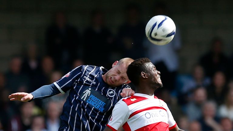 Millwall's Alan Dunne heads away from Doncaster's Theo Robinson