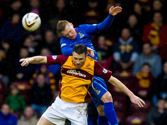 Inverness's Billy McKay right rises above Stephen McManus
