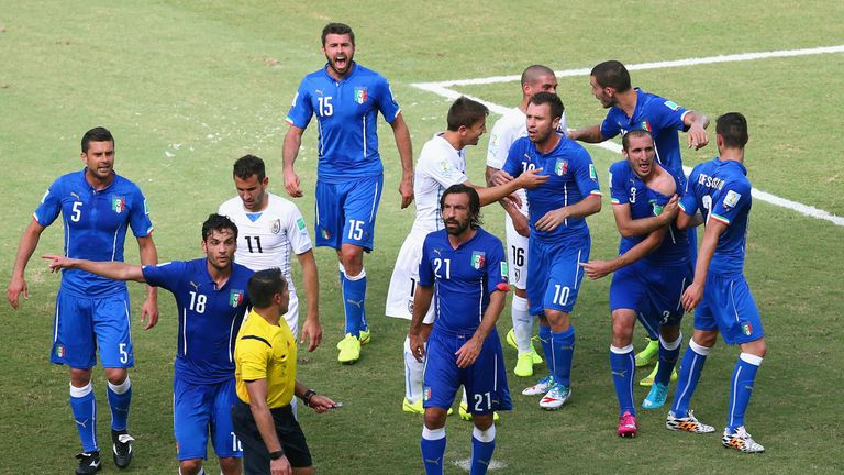 Giorgio Chiellini of Italy pulls down his shirt to show apparent bite marks after a clash with Luis Suarez.