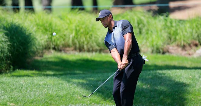 Tiger Woods chips to the practice green in preparation for the Quicken Loans National