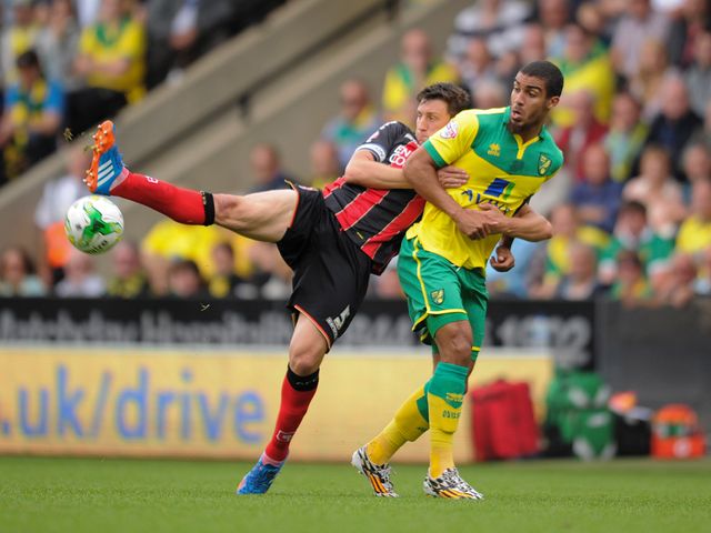 Norwich City's Lewis Grabban (right) is challenged by Bournemouth's Tommy Elphick