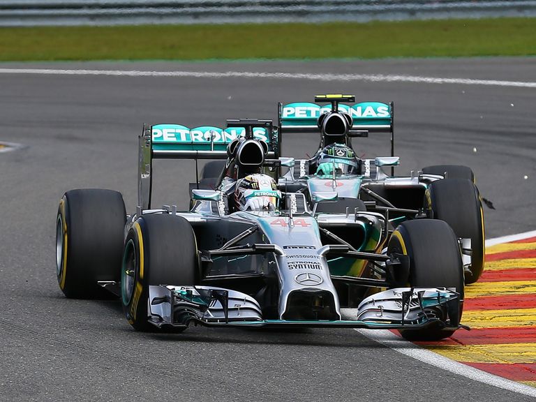 Debris flies in the air after Rosberg makes contact with Hamilton