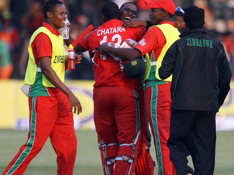 Zimbabwe captain Elton Chigumbura is mobbed by his players after victory over Australia