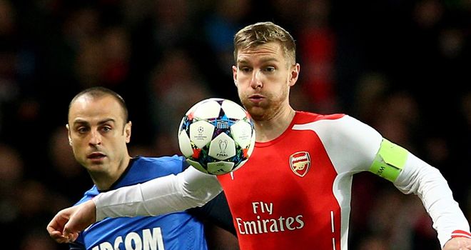Per Mertesacker controls the ball as Dimitar Berbatov closes him down