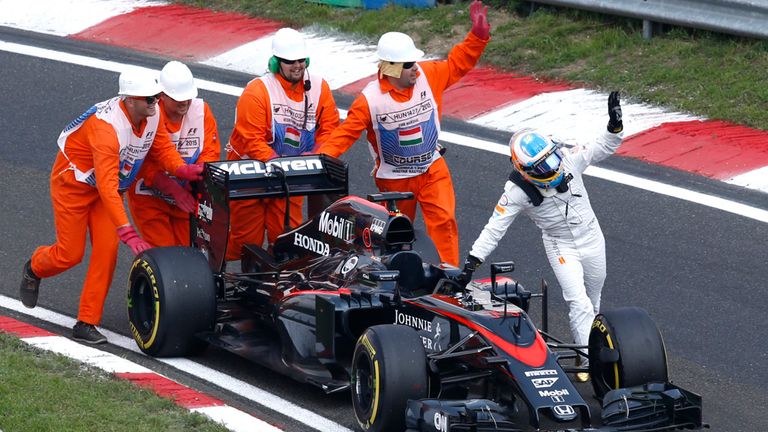 Fernando Alonso  pushes his McLaren car during qualifying for the Hungarian GP