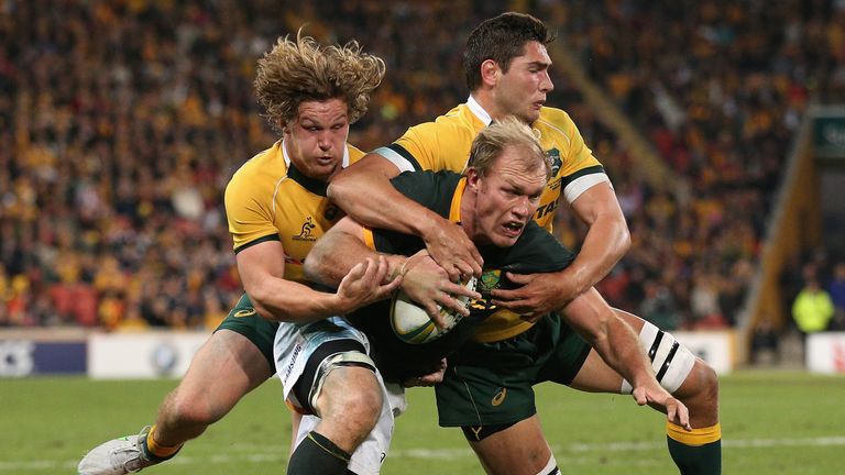 Schalk Burger is tackled by Michael Hooper and Rob Simmons