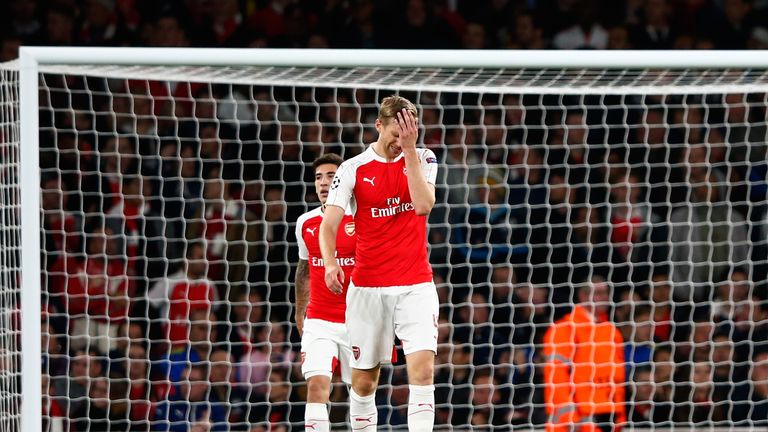 Per Mertesacker is dejected as Arsenal concede a critical third goal to Olympiakos