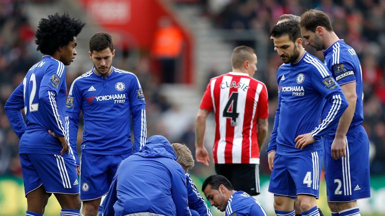 Chelsea's Pedro (centre) receives treatment for a injury
