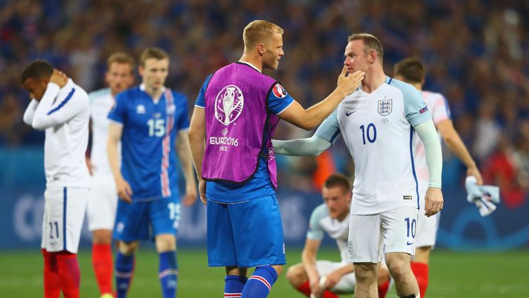Wayne Rooney is consoled by Eidur Gudjohnsen of Iceland after England's shock defeat