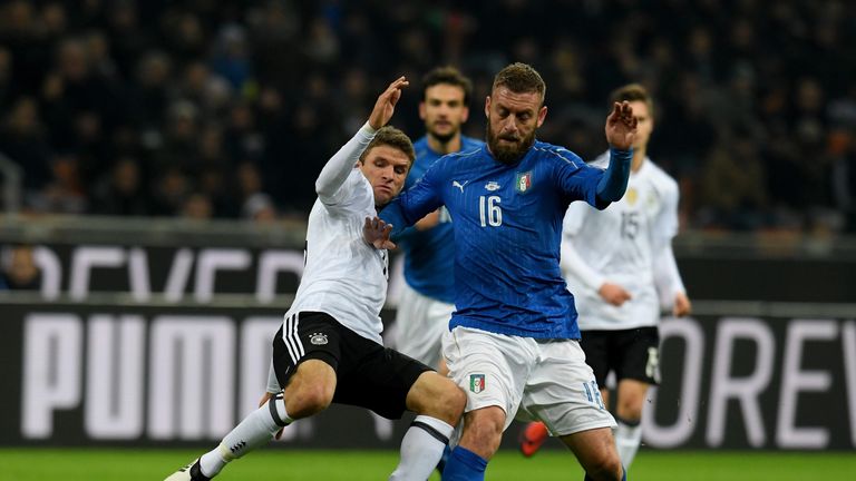 Italy midfielder Daniele De Rossi (right) is tackled by Germany counterpart Thomas Muller