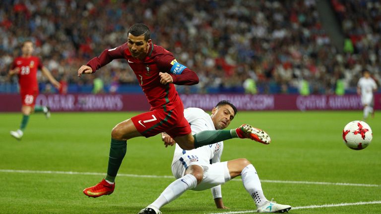 Gonzalo Jara of Chile tackles Cristiano Ronaldo