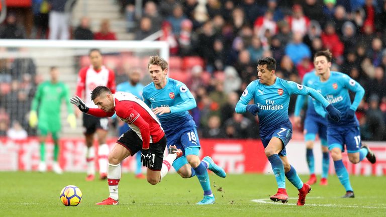 Alexis Sanchez and Nacho Monreal vie for the ball with Dusan Tadic