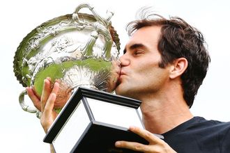 Roger Federer kisses the Norman Brookes Challenge Cup the day after defending his Australian Open title