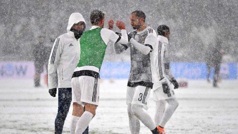 Juventus' players warm up under heavy snowfall