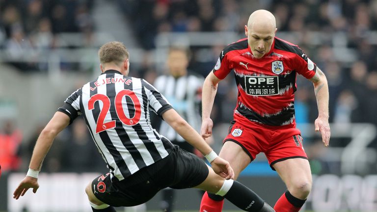 Newcastle United's Florian Lejeune challenges Huddersfield Town's Aaron Mooy