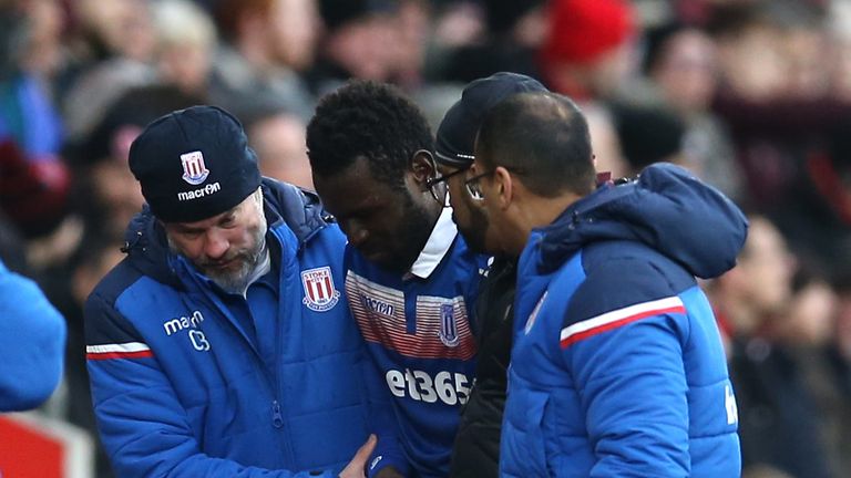 Mame Diouf leaves the pitch clutching his wrist after colliding with Wesley Hoedt