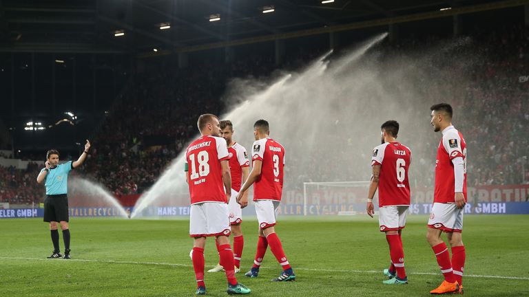 Referee Guido Winkmann tells the Mainz players to return to the pitch