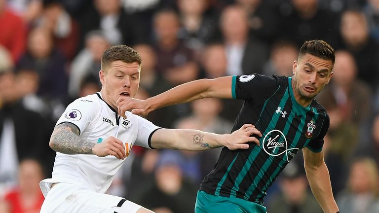 Alfie Mawson battles for the ball with Dusan Tadic