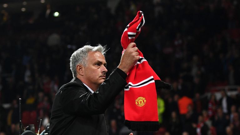 Jose Mourinho clutches a Manchester United scarf as he stands before the home fans at Old Trafford