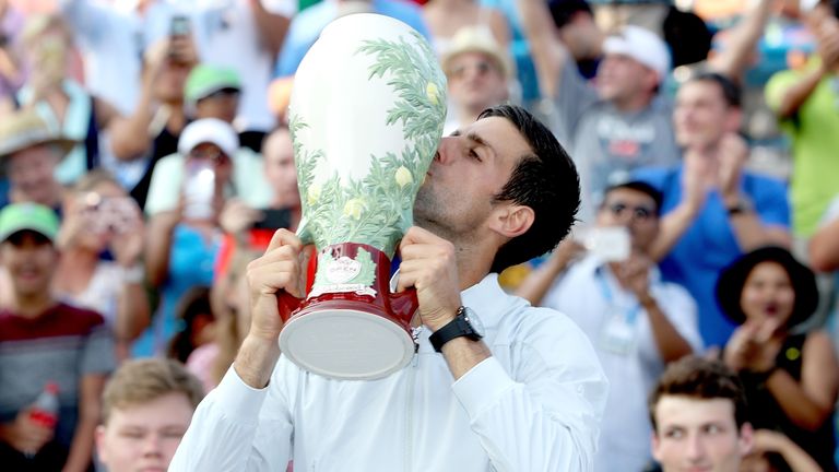 Djokovic celebrates with the trophy after beating Roger Federer in straight sets in the final