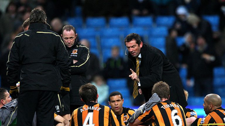 Phil Brown conducts his half-time team talk on the pitch.