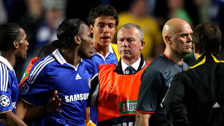 Drogba goes after the official at full-time and needs to be restrained by stewards.