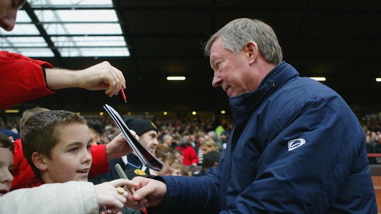 Sir Alex takes some time to sign a few autographs following a Premier League match in 2004.
