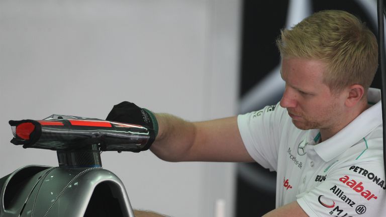 A Mercedes mechanic works on Schumacher's car