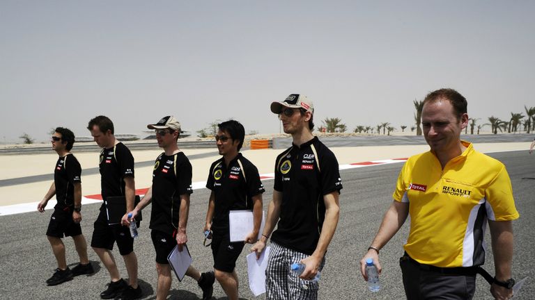 Romain Grosjean walks the track with the Lotus team