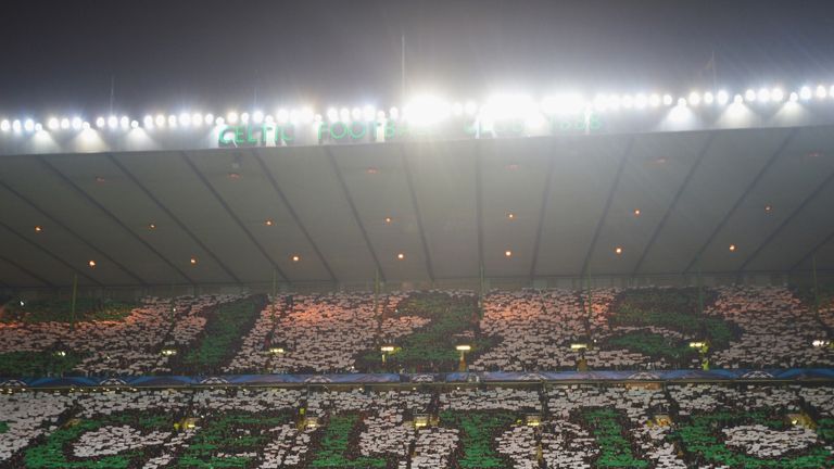 Celtic fans hold up cards to spell out a sign during the Champions League match between Celtic and Barcelona.