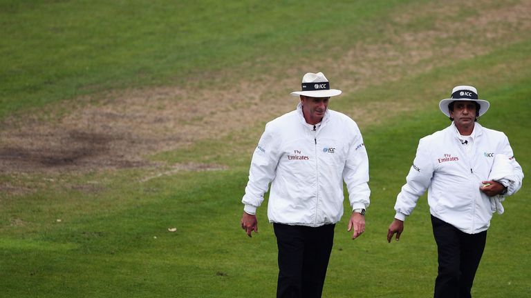 Umpires Paul Reiffel and Asad Rauf walk off the pitch due to bad light during day three of the first Test between New Zealand and England at University Oval, Dunedin