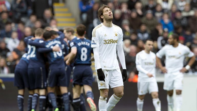 Swansea City's Spanish midfielder Miguel Michu reacts after Tottenham Hotspur players celebrate their opening goal during the Premiership match at The Liberty Stadium.n