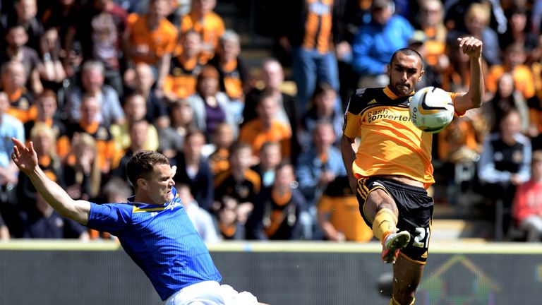 Ahmed Elmohamady of Hull clears the ball as Ben Turner of Cardiff closes in 