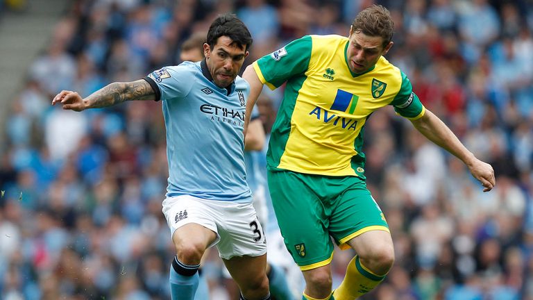 Manchester City's Carlos Tevez holds off Norwich City's Grant Holt 