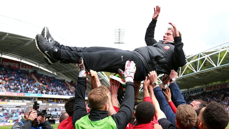 Barnsley manager David Flitcroft is thrown into the air by his players 