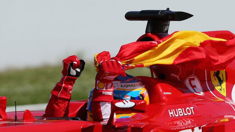 Fernando Alonso laps the track with the Spanish flag