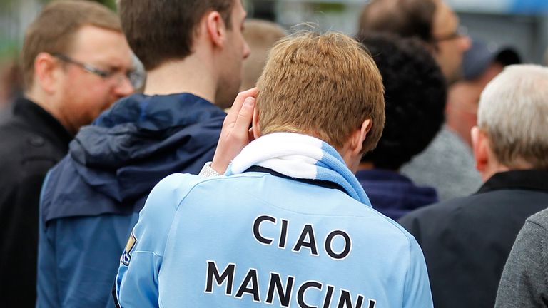 A Manchester City fan wears football shirt bidding farewell to former manager Roberto Mancini 