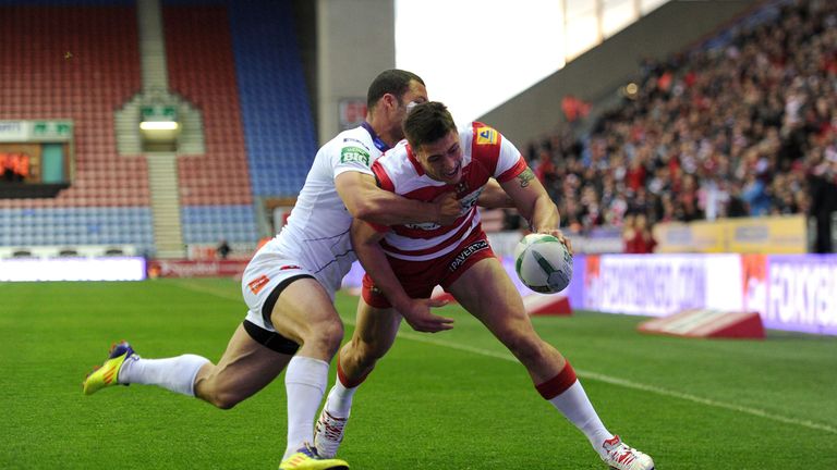 Wigan Warriors Anthony Gelling goes over for a try past Salford City Reds' Danny Williams during the Super League match at the DW Stadium.