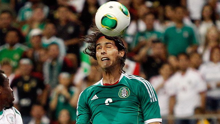 HOUSTON - MAY 31:  Aldo De Nigris #9 0f Mexico heads the ball on goal as Efe Ambrose #5 of Nigeria looks on at Reliant Stadium on May 31, 2013 in Houston, Texas.  (Photo by Bob Levey/Getty Images)