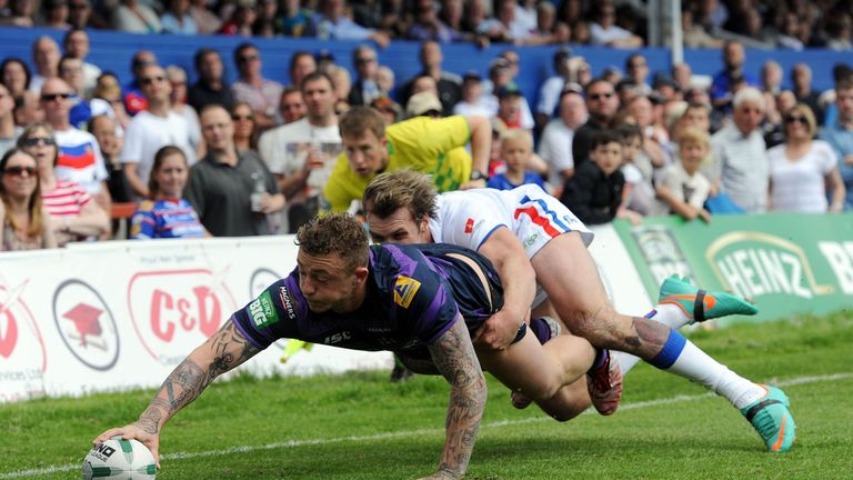 Josh Charnley scores a try under pressure from Wakefield Wildcats' Lucas Walshaw during the Super League match at The Rapid Solicitors Stadium